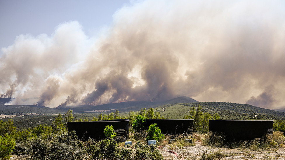 Water tanks for firefighting helicopters are pictured after wildfires broke out in the area of Magoula, southwest of Athens, Greece