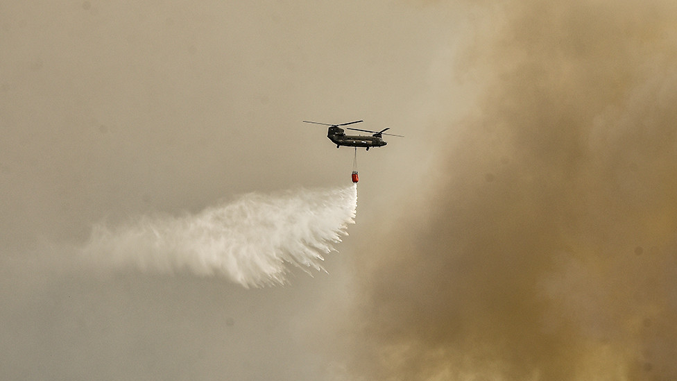 A military Chinook helicopter flies over the area of Magoula, near Athens, Greece