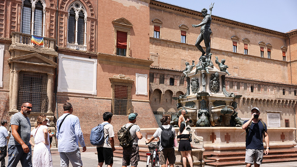 People queue to refill their water bottles at the Fountain of Neptune in Bologna, Italy, on 18 July 2023