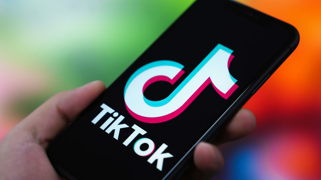 the TikTok logo is displayed on the screen of a smartphone