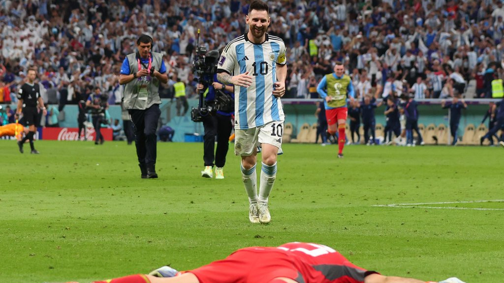 Lionel Messi approaches a prostrate Emi Martinez after Argentina's penalty shoot-out win over the Netherlands at the 2022 World Cup