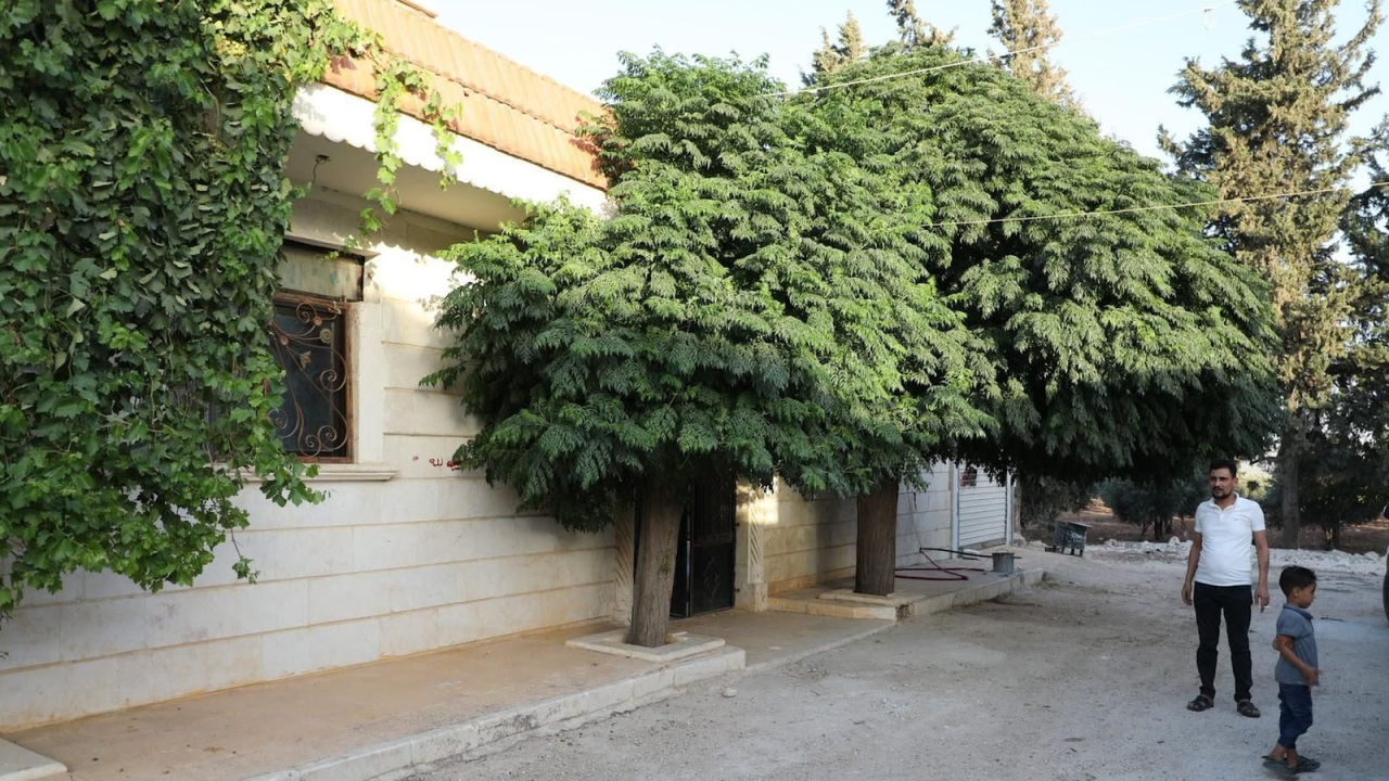 Khalil outside of his new home with his boy