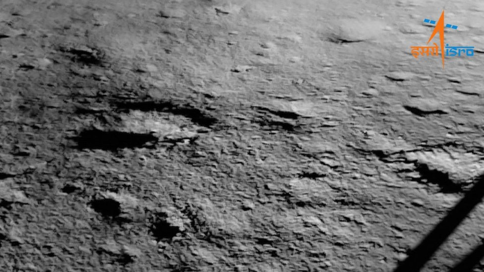 An Isro image of the Chandrayaan-3 landing site taken after touchdown. One of the four legs of the lander is visible on the right