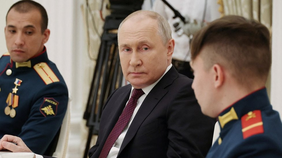 Putin speaks to two military people