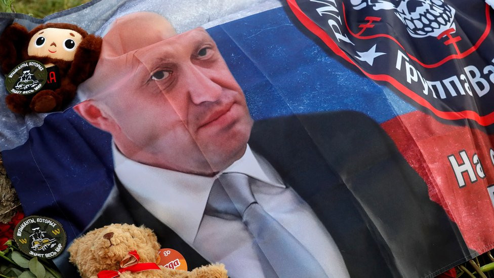 Zastava sa likom Prigožina ispred sedišta Vagnera u Sankt Peterburgu, gde ljudi odaju počast