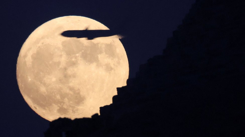 A plane flies by the blue supermoon rising above the Pyramids of Giza in Egypt. Photo: 30 August 2023
