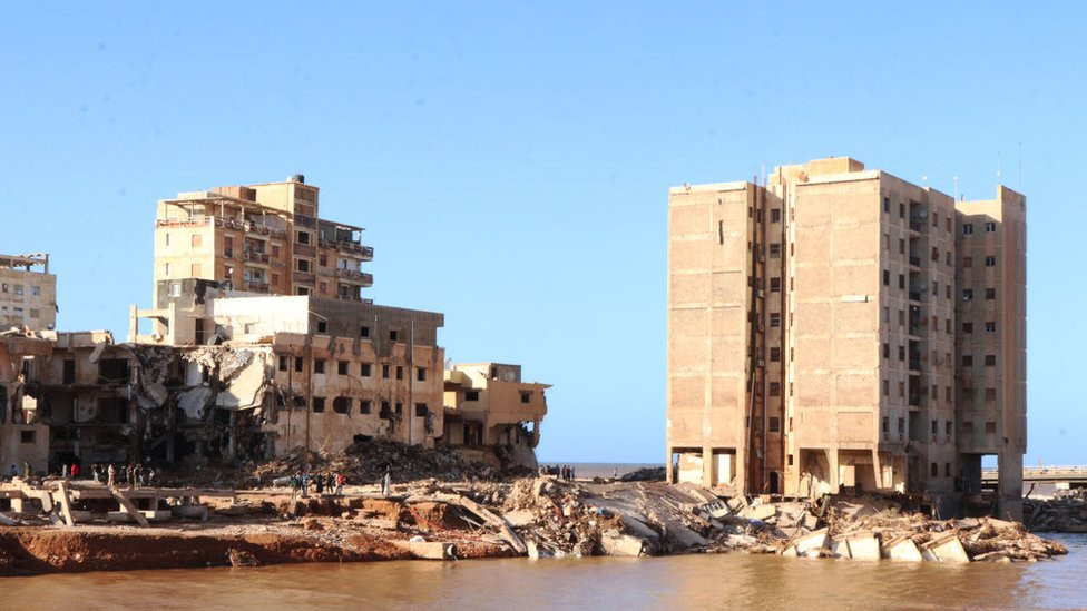 The remains of Amna's building, right, after it partially collapsed in the flood.