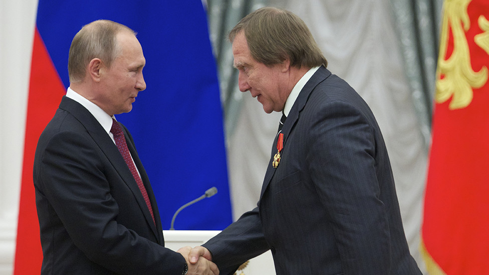 Vladimir Putin (L) shakes hands with Russian cellist Sergei Roldugin during an awarding ceremony at the Kremlin in Moscow on September 22, 2016