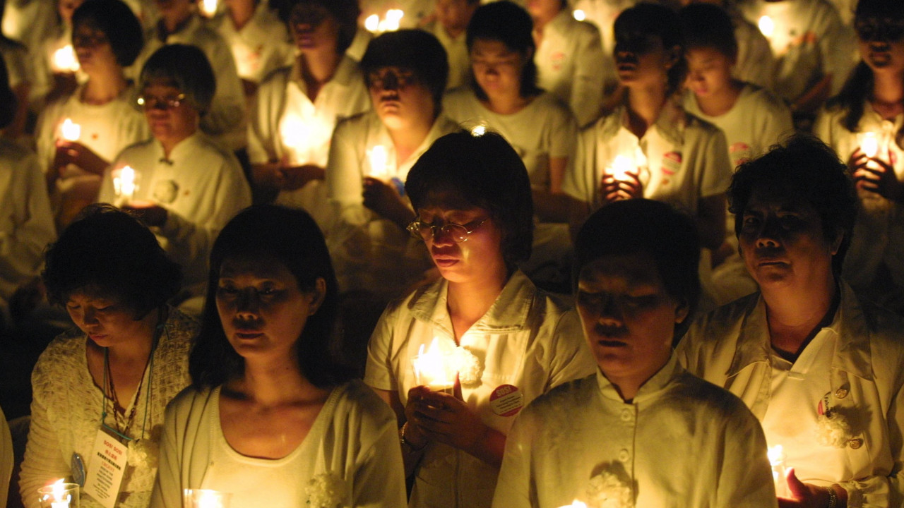 Members of the Falun Gong spiritual movement hold candles during a candlelight vigil July 19, 2001 in Washington, DC