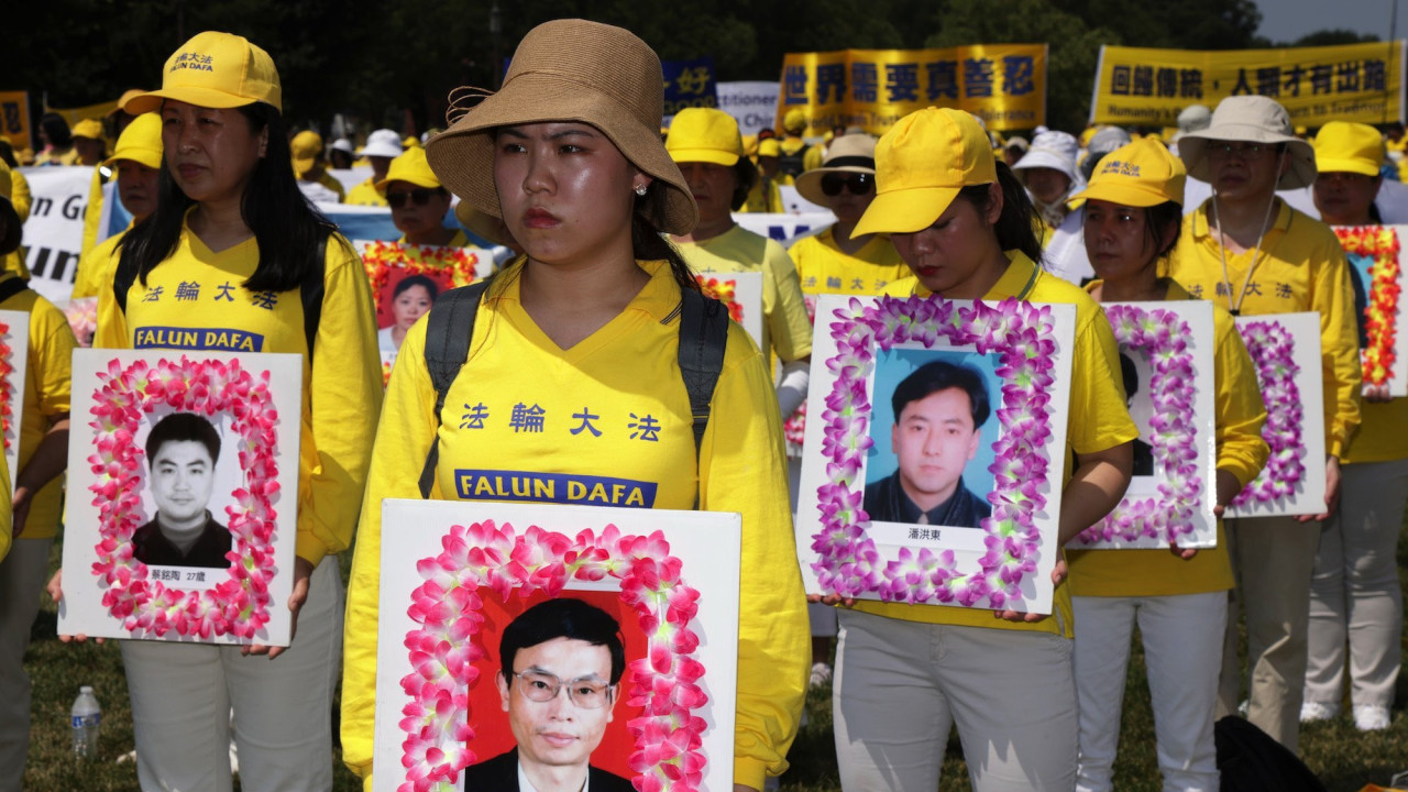 Falun Gong protesters hold images of members they say were killed by the Chinese state