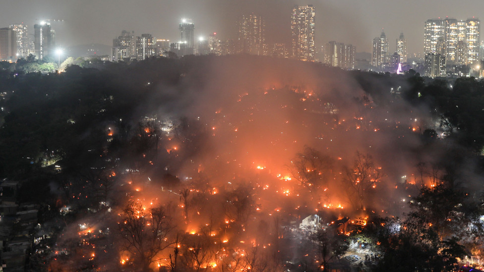 Smoke billows after a level-three fire broke out inside the Appa Pada slums in Mumbai, India, 13 March 2023.