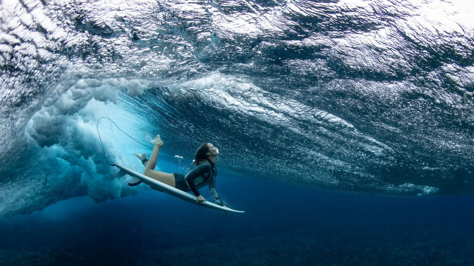 Australian surfer Olivia Ottaway dives under a wave on August 19, 2023 in Teahupo'o, French Polynesia.