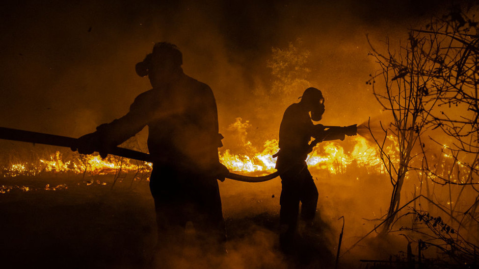 Firefighters attempt to extinguish a wildfire on burned peatland and fields on September 23, 2023 in Ogan Ilir, South Sumatra, Indonesia.