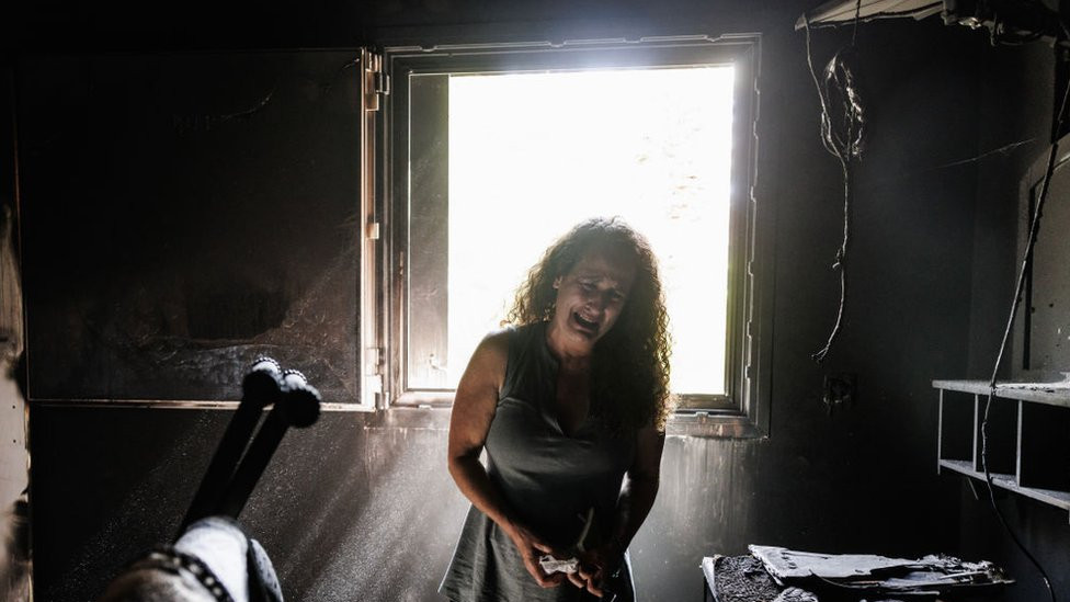 Kibbutz Nir Oz resident Hadas Kalderon, whose children were taken hostage, and her mother and niece killed, breaks down in tears while looking through the burnt out home of her late mother Rina Sutzkever on October 30, 2023 in Kibbutz Nir Oz, Israel.