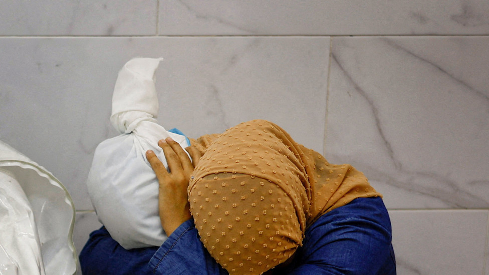 Palestinian woman Inas Abu Maamar, 36, embraces the body of her 5-year-old niece Saly, who was killed in an Israeli strike, at Nasser hospital in Khan Younis in the southern Gaza Strip, October 17, 2023.