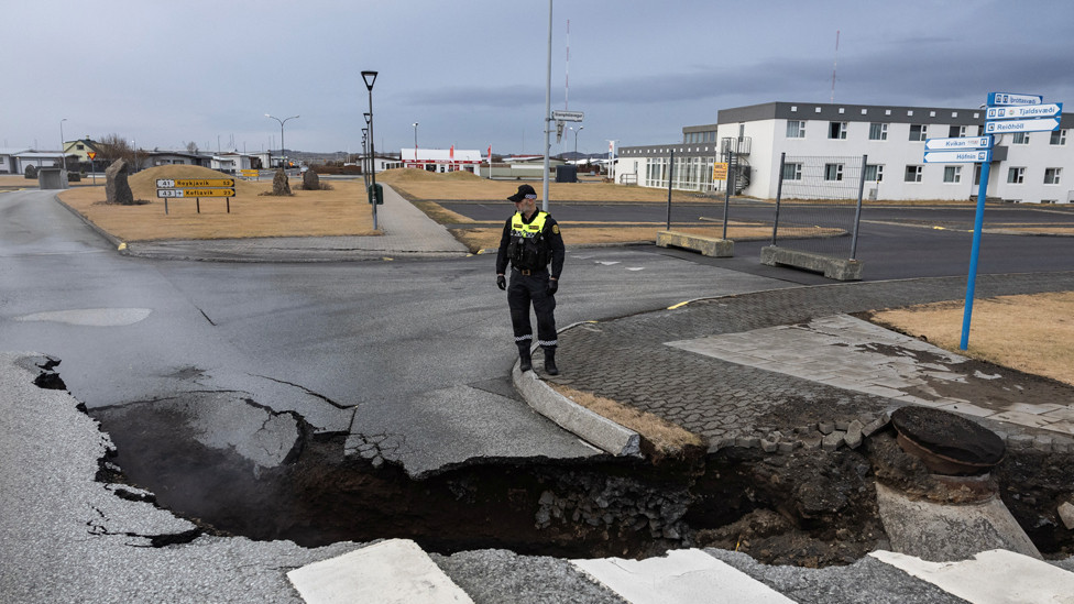 A police officer stands by a crack in a road in the fishing town of Grindavik, which was evacuated due to volcanic activity, in Iceland. November 15, 2023.