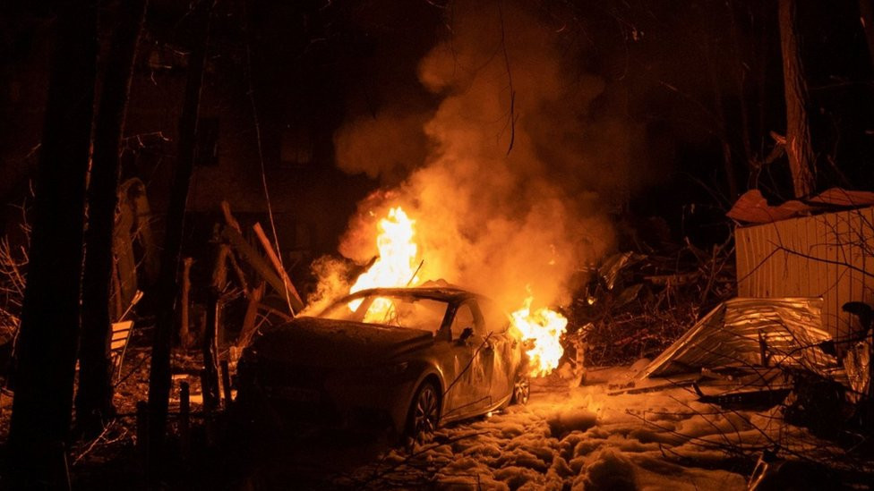 A view of a burning car following a Russian missile strike on a residential building in Kharkiv, on 30 December 2