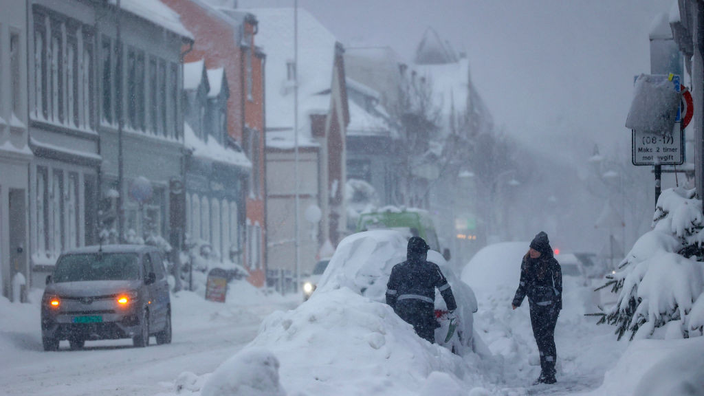 People remove snow from a car in Kristiansand, Norway, on 2 January.