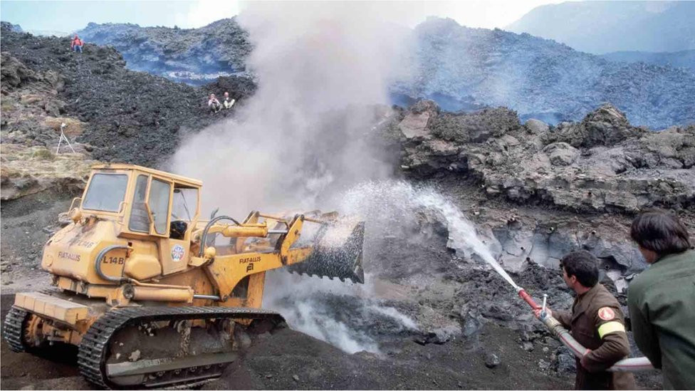 Italijanski vatrogasci pokušavaju da vodom i mašinama preusmere lavu na planinu Etna