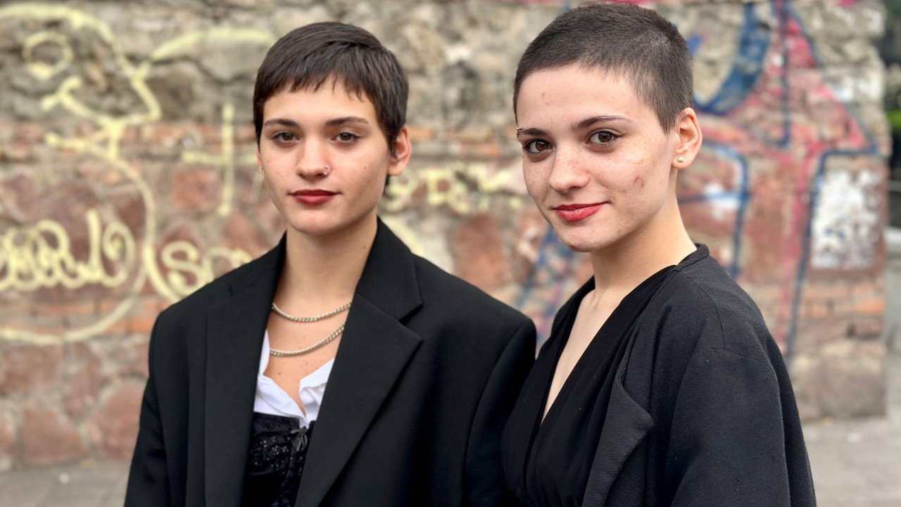 Ano (L) and Amy (R) standing in front of graffiti wall