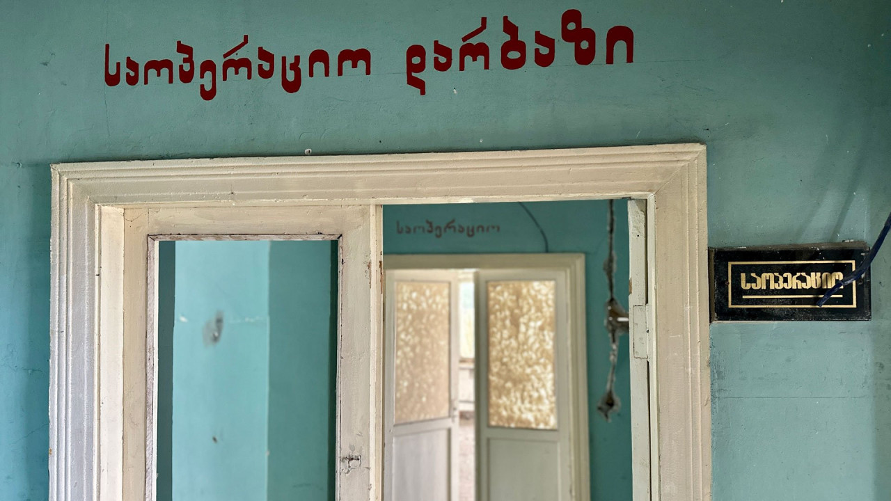 A Georgian sign over a hallway in a derelict hospital