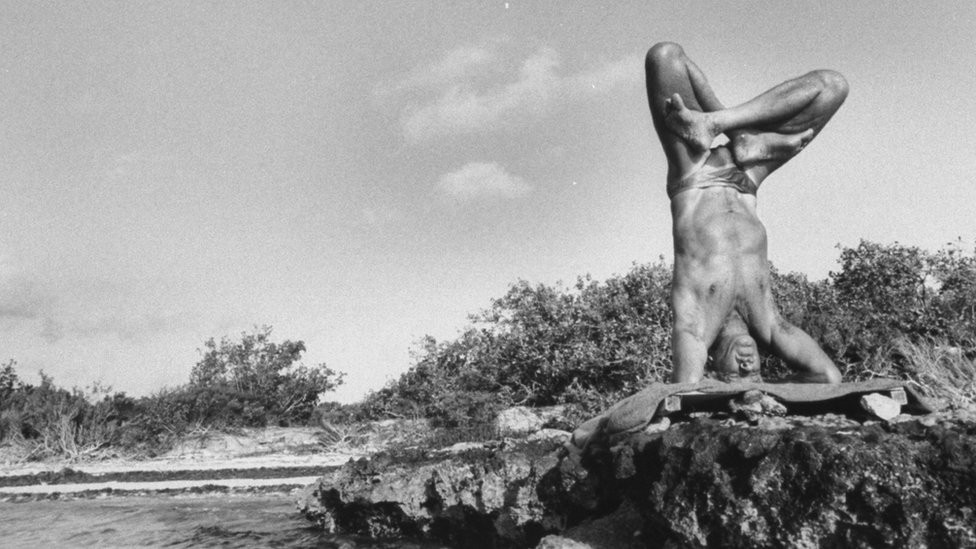 Jacques Mayol in headstand position with legs crossed, practicing Yoga