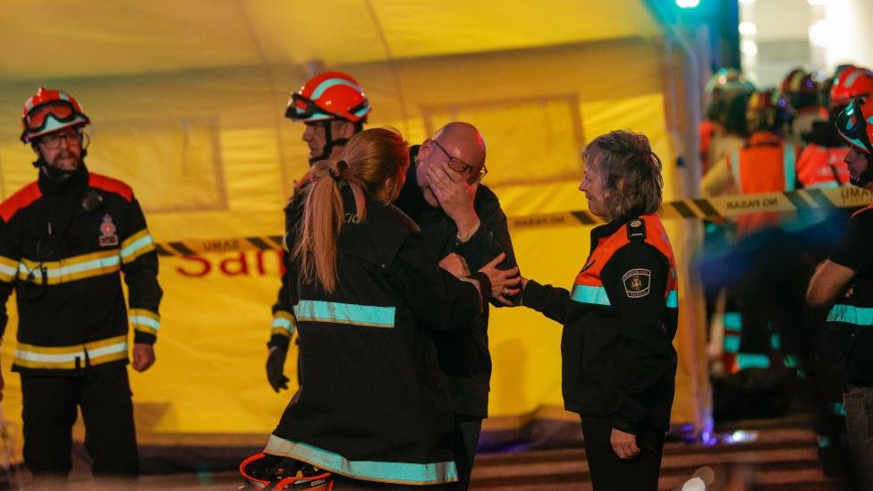 A man and emergency services at the scene of a fire