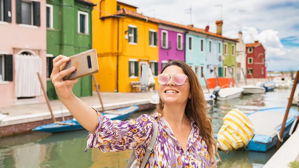 selfi, žena se slika na obali mora