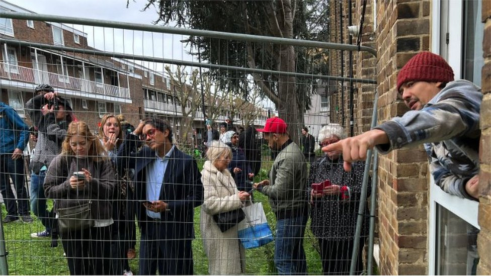 Carlos Serrano leans out of his window, offering opinions on Banksy's work