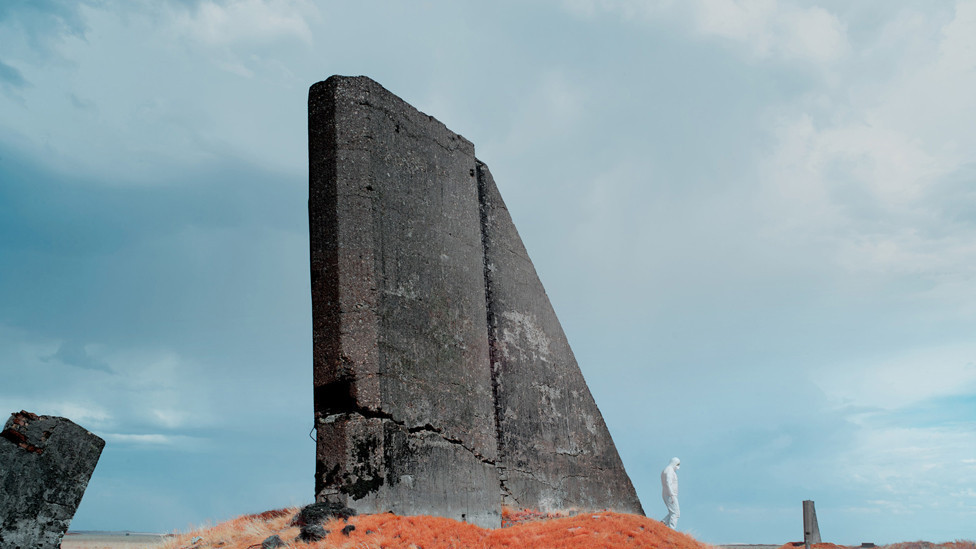 Scientist in protective clothing walks through landscape of a remote area of Kazakhstan used for nuclear testing