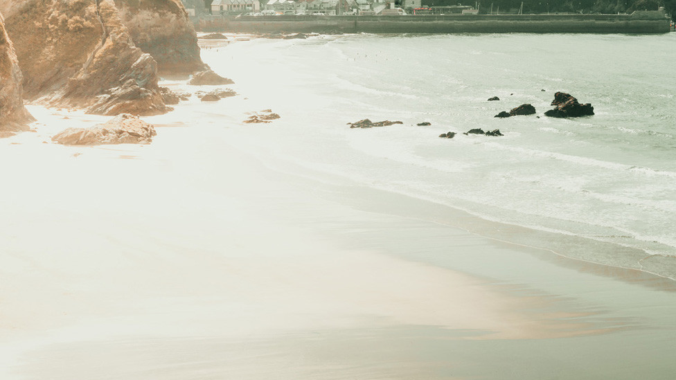 A solitary surfer on an empty Cornish beach