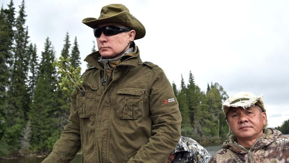 Vladimir Putin (left), accompanied by Sergei Shoigu, guides a boat in the remote Tuva region in southern Siberia, August 2017