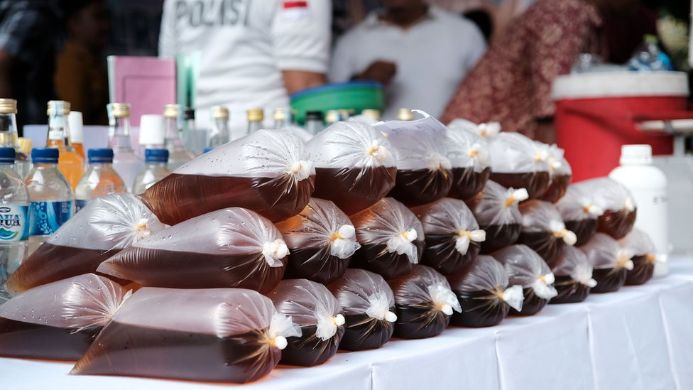 Kese napunjene crvenim ilegalnim alkoholnim pićem prodaju se na štandu