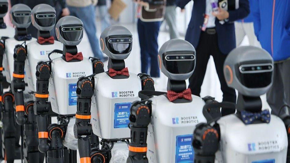 Šest humanoidnih robota hoda tokom sajma trgovine u Kini, 26. mart 2025. 