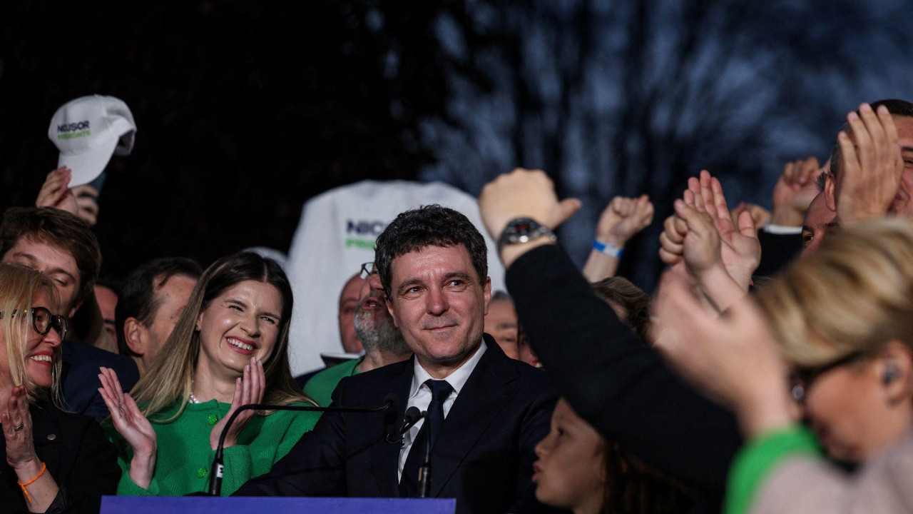 Muškarac okružen pristalicama gleda u masu sa osmehom na licu