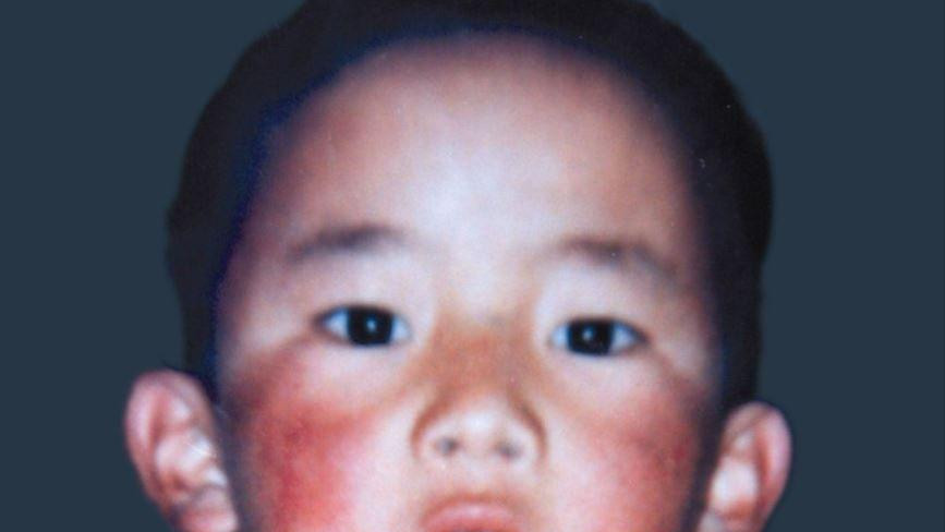 Slika Geduna Čoekija Nijumua, crvenih obraza gleda direktno u kameru. Imao je šest godina kada je nestao. 