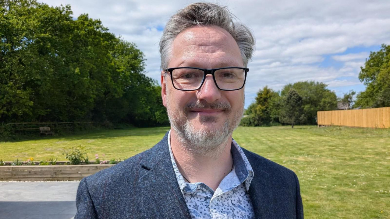 Garet stoji na velikom travnjaku kuće Brinavel u pozadini. 