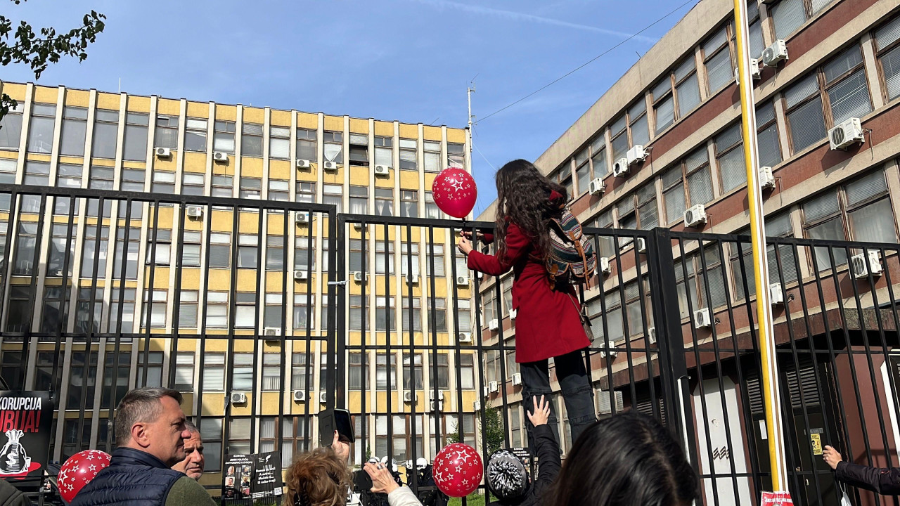 Devojka kači crveni balon