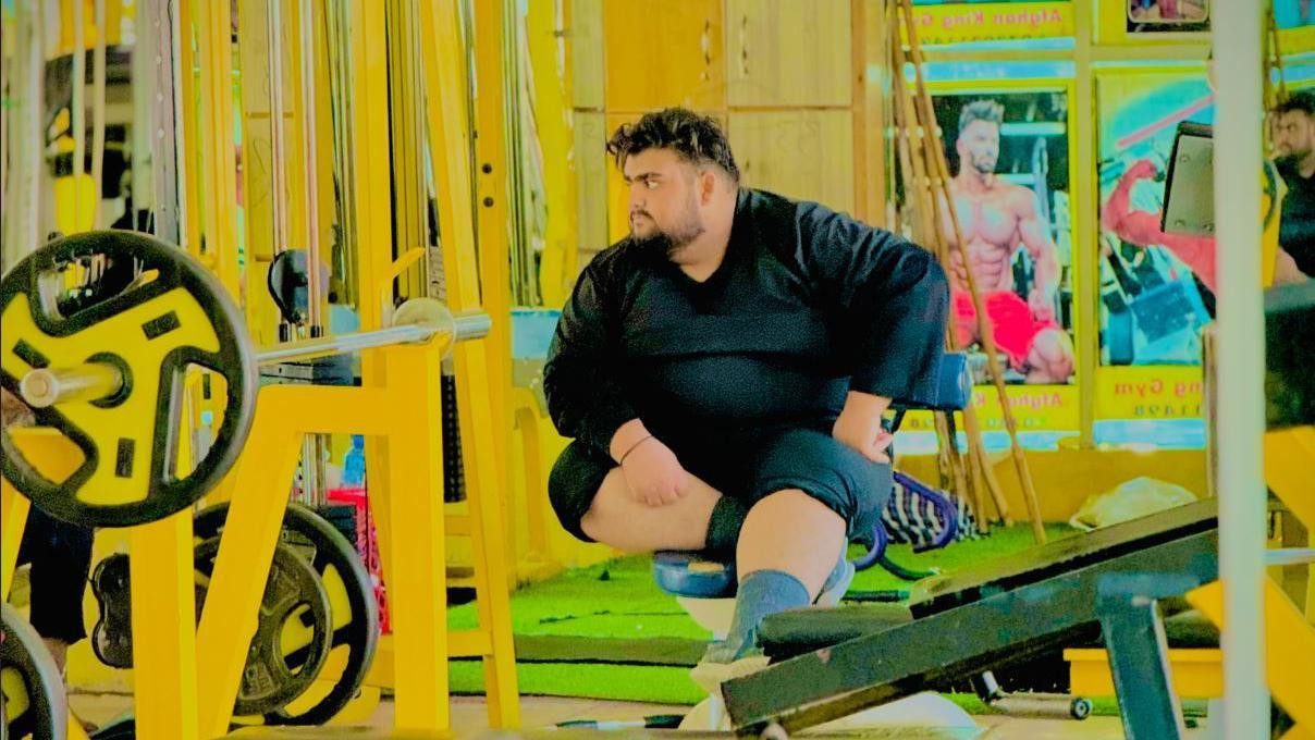 Qudratullah  wearing a black shirt and sitting in a gym 