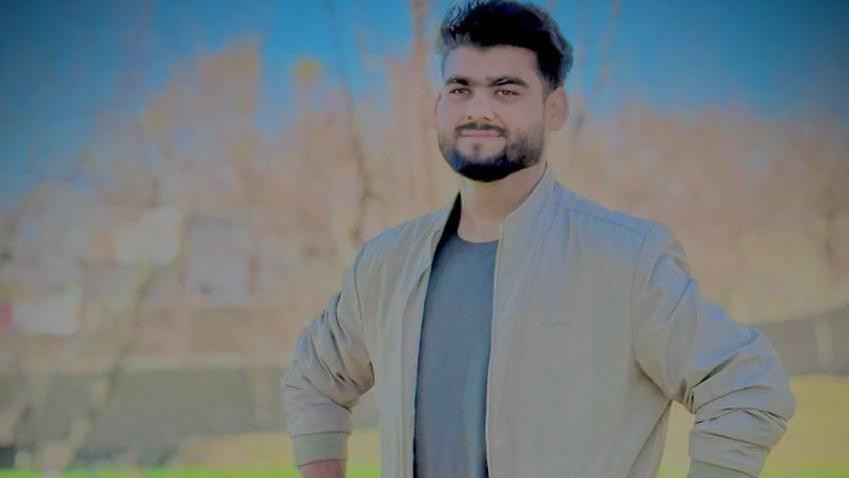 Qudratullah  standing in a green field 