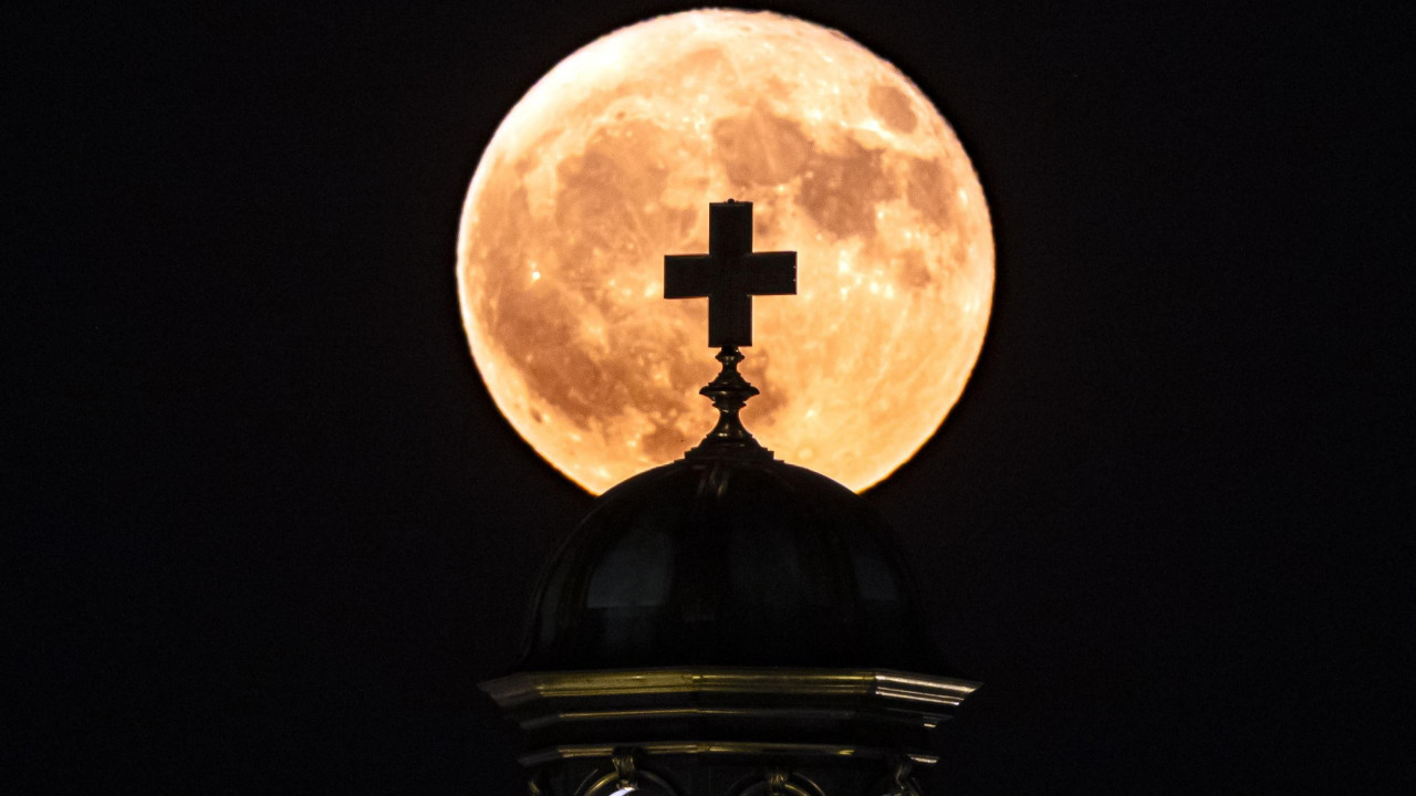 mesec obasjava krst na kupoli crkve 