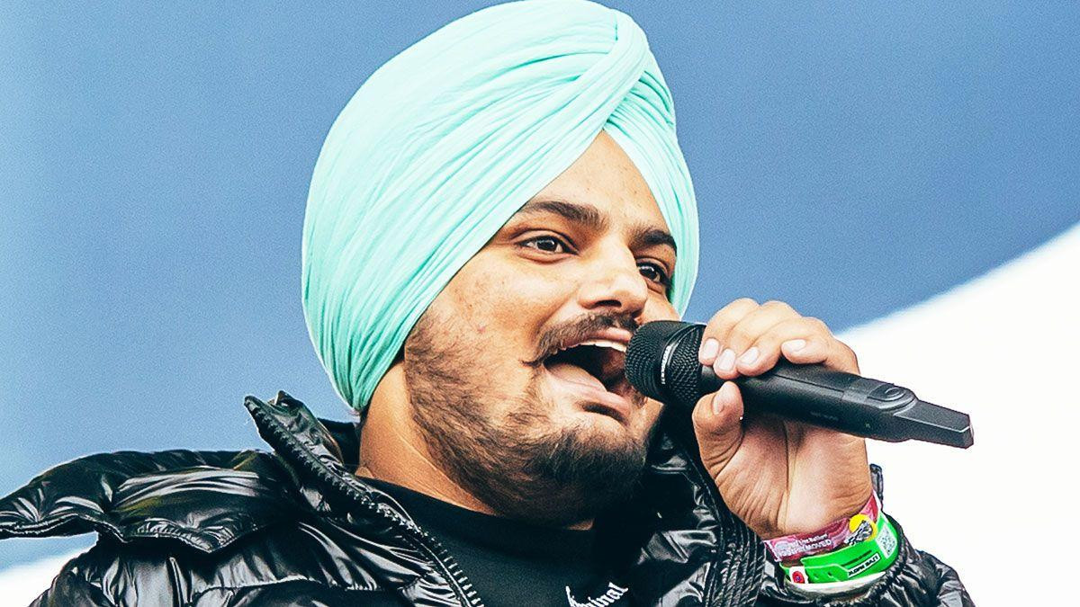 Mus Vala nastupa na festivalu u Londonu 2021. godine, drži mikrofon u rukama i ima svetlo zeleni turban na glavi