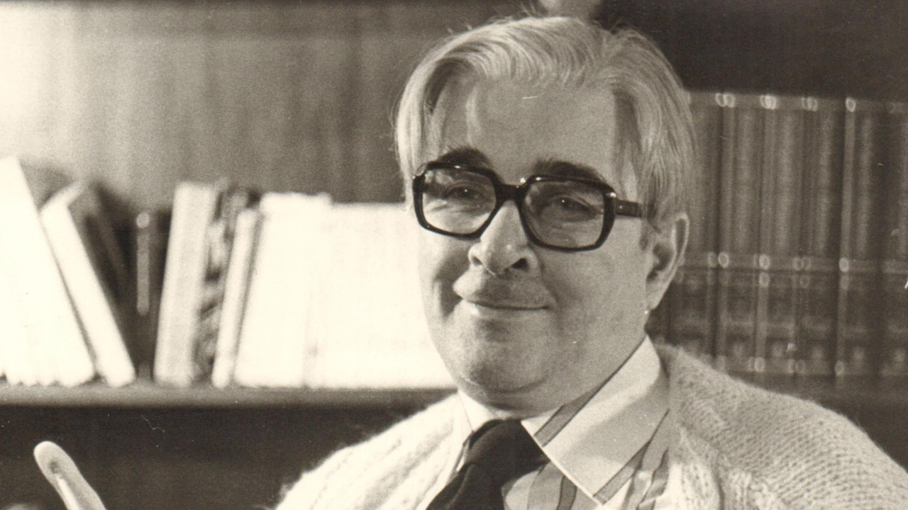 Bogdan Bogdanović u beloj košulji sa kravatom gleda u kameru, sa naočalama na licu, crno-bela fotografija, portret