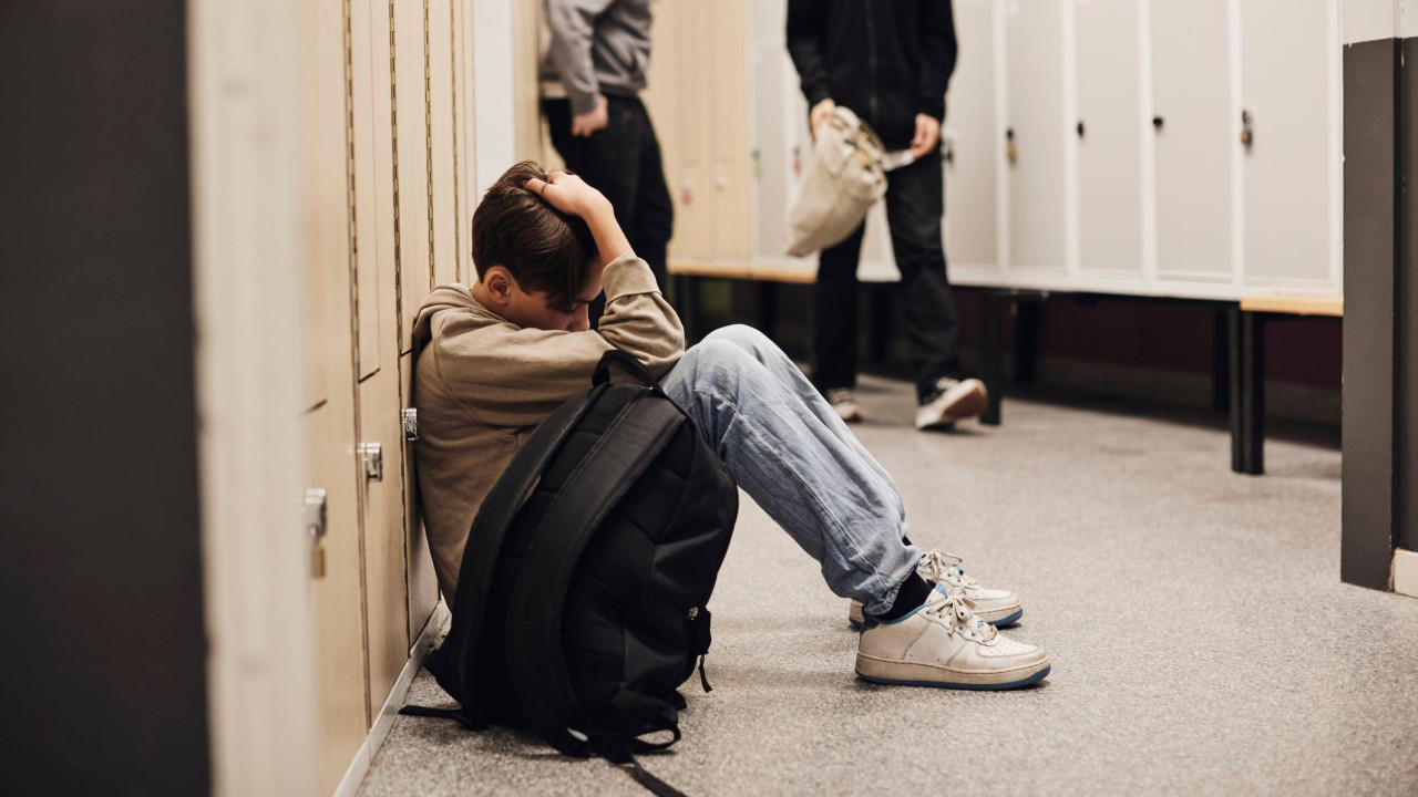 Dečak sedi na podu škole