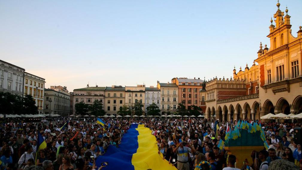 Demonstranti nose veliku ukrajinsku zastavu na protestu u Varšavi u avgustu 2023. 