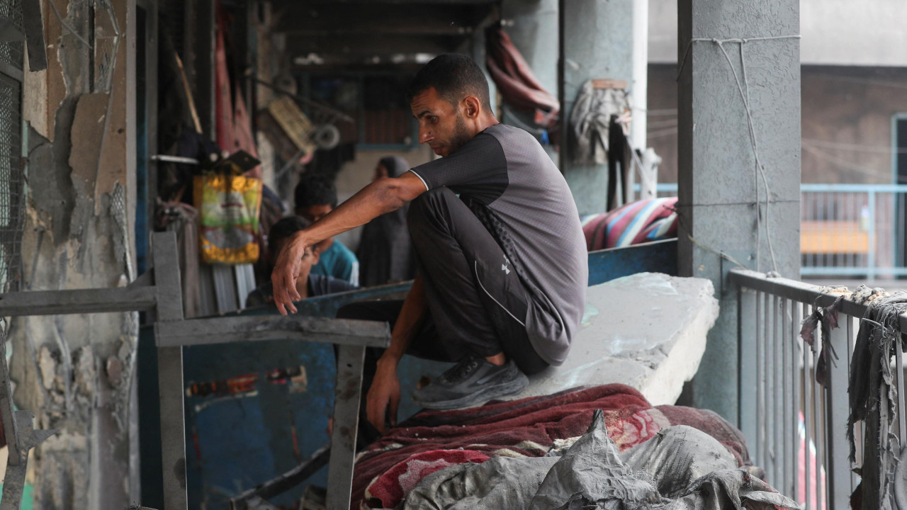 Muškarac sedi na ruševinama