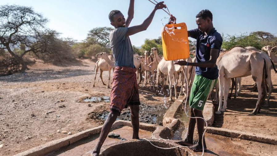 Dva mlada Afrikanca izvlače vodu iz bunara