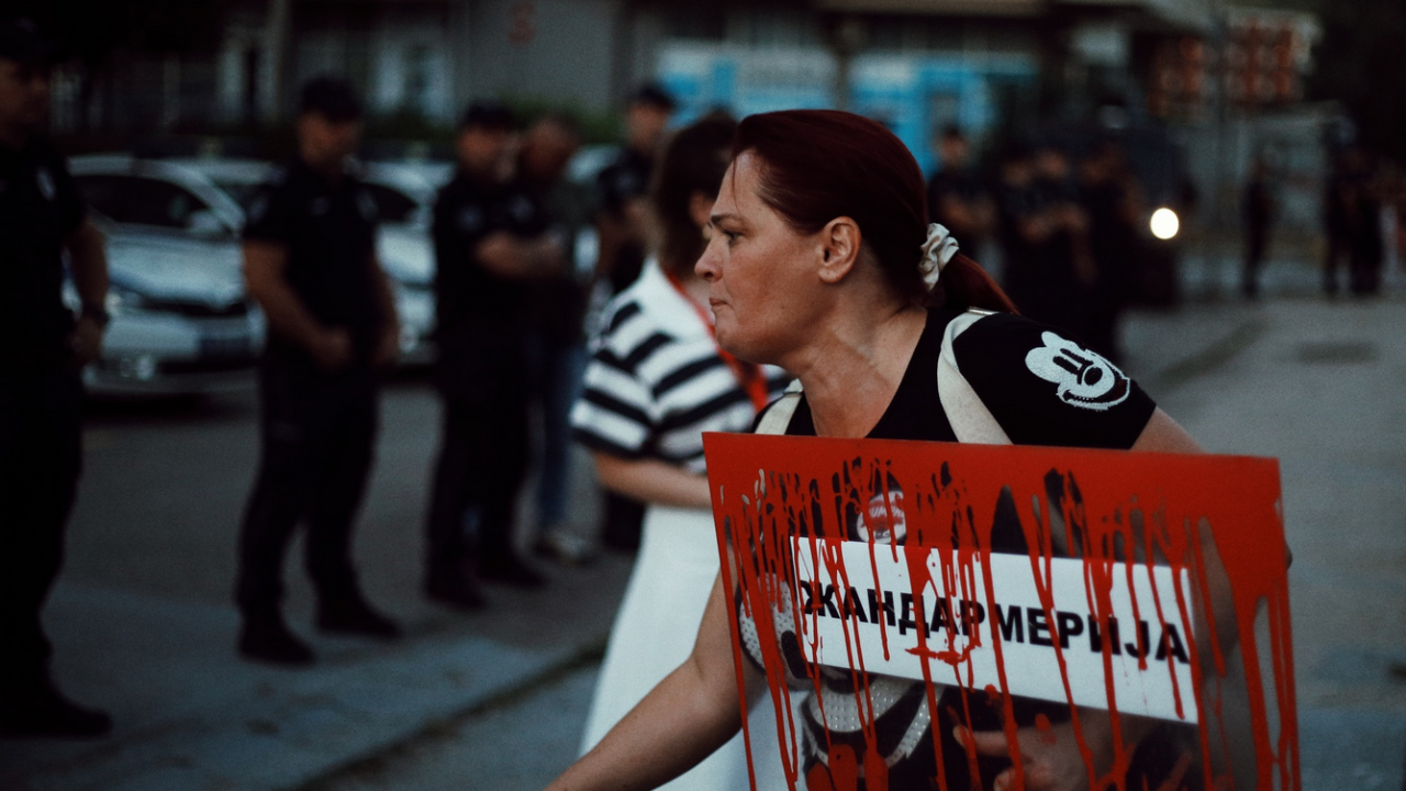 žena sa transparentom protiv žandarmerije