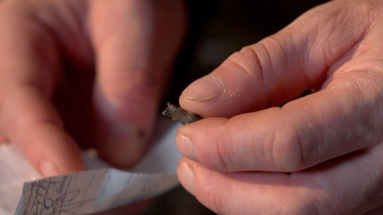 Ukrajinski regrut Sergej Melnik drži komad šrapnela koji mu je nekada bio zabijen u srce