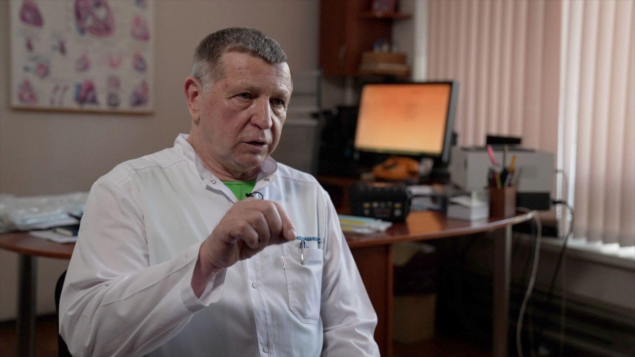 Sergej Maksimenko objašnjava rukama dok u beloj košulji sedi u prostoriji